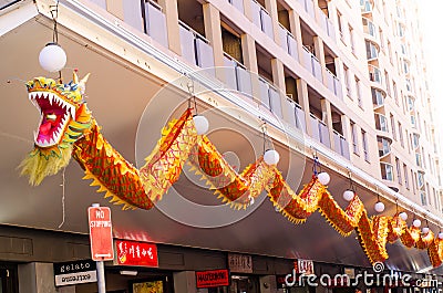 Orange long Dragon Artwork hanging at facade building in Chinatown. Editorial Stock Photo